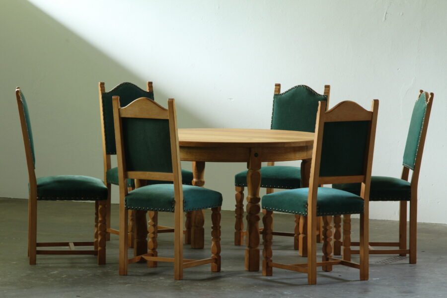 Round vintage Danish brutalist oak dining table with green velvet high-back chairs, carved baluster legs, Henning Kjærnulf style, 1960s